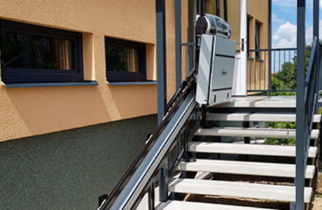 Nově zrekonstruovaný vchod do bytovky s instalovanou šikmou pojízdnou plošinou pro vozíčkáře v Luži