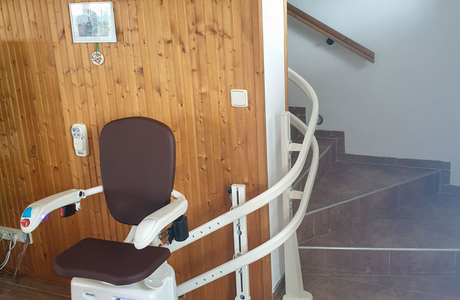 Schodišťová sedačka připravená k přepravě imobilní osoby do schodů v domě