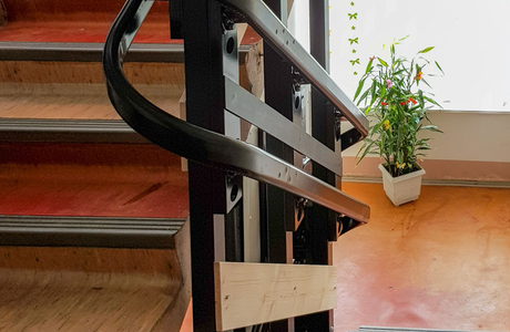 Vodící kolejnice plošiny pro vozíčkáře upevněná přímo na konstrukci zábradlí.