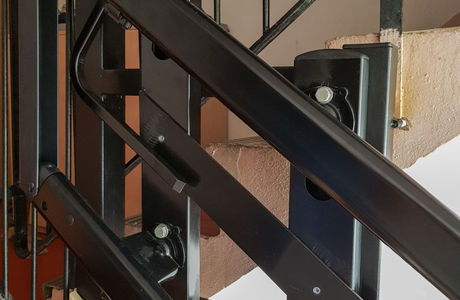 Vodící dráha pojízdné plošiny upevněná na konstrukci zábradlí v bytovém domě