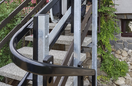 Vodící dráha plošiny pro vozíčkáře je zahnutá ve spodní části tak, aby umožnila bezpečné parkování plošiny mimo plochu schodiště